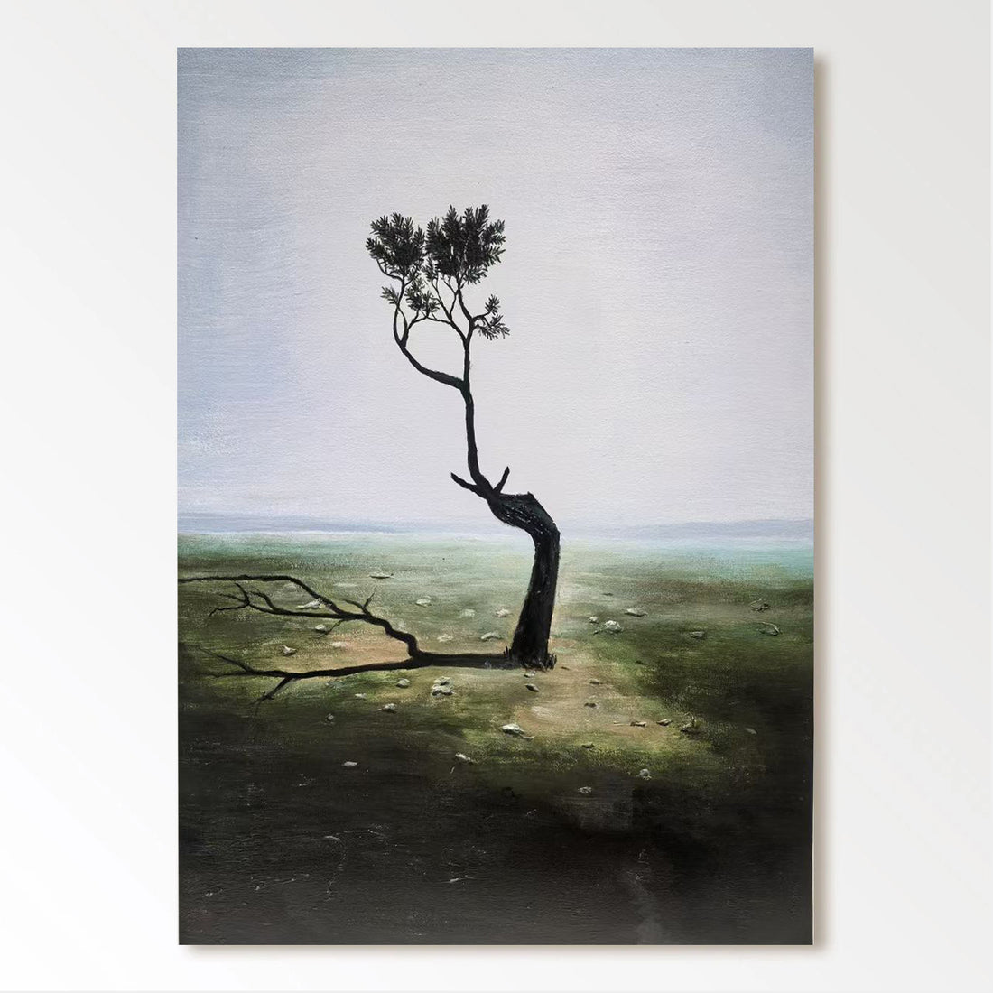 a lone, twisted tree standing in a barren, grassy field with a hazy, overcast sky in the background.