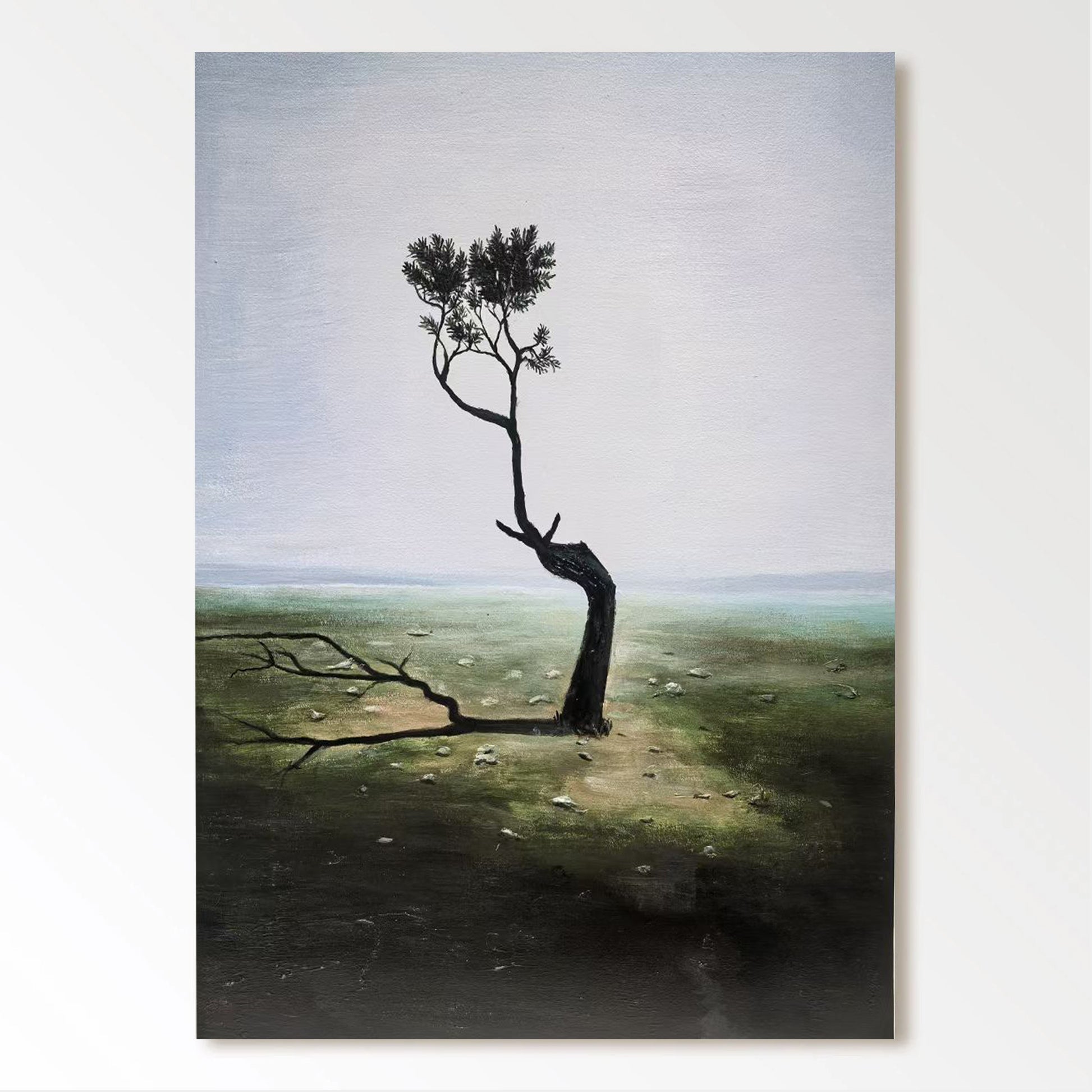 a lone, twisted tree standing in a barren, grassy field with a hazy, overcast sky in the background.
