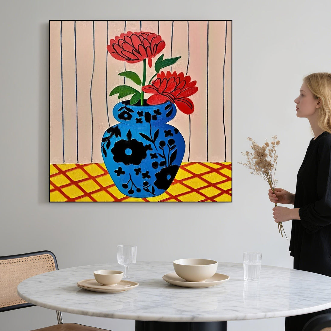 A blue vase with red flowers is placed on a yellow and red checkered surface against a striped background.