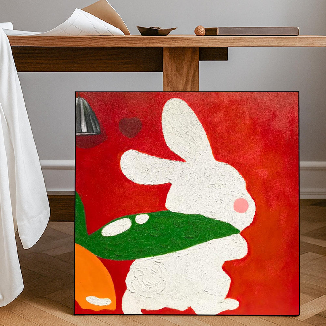 The image is a vibrant painting featuring a white rabbit in a green leafy shape against a red background.
