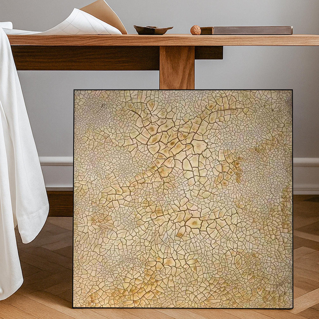 a square canvas with a textured, cracked surface in various shades of brown and beige.
