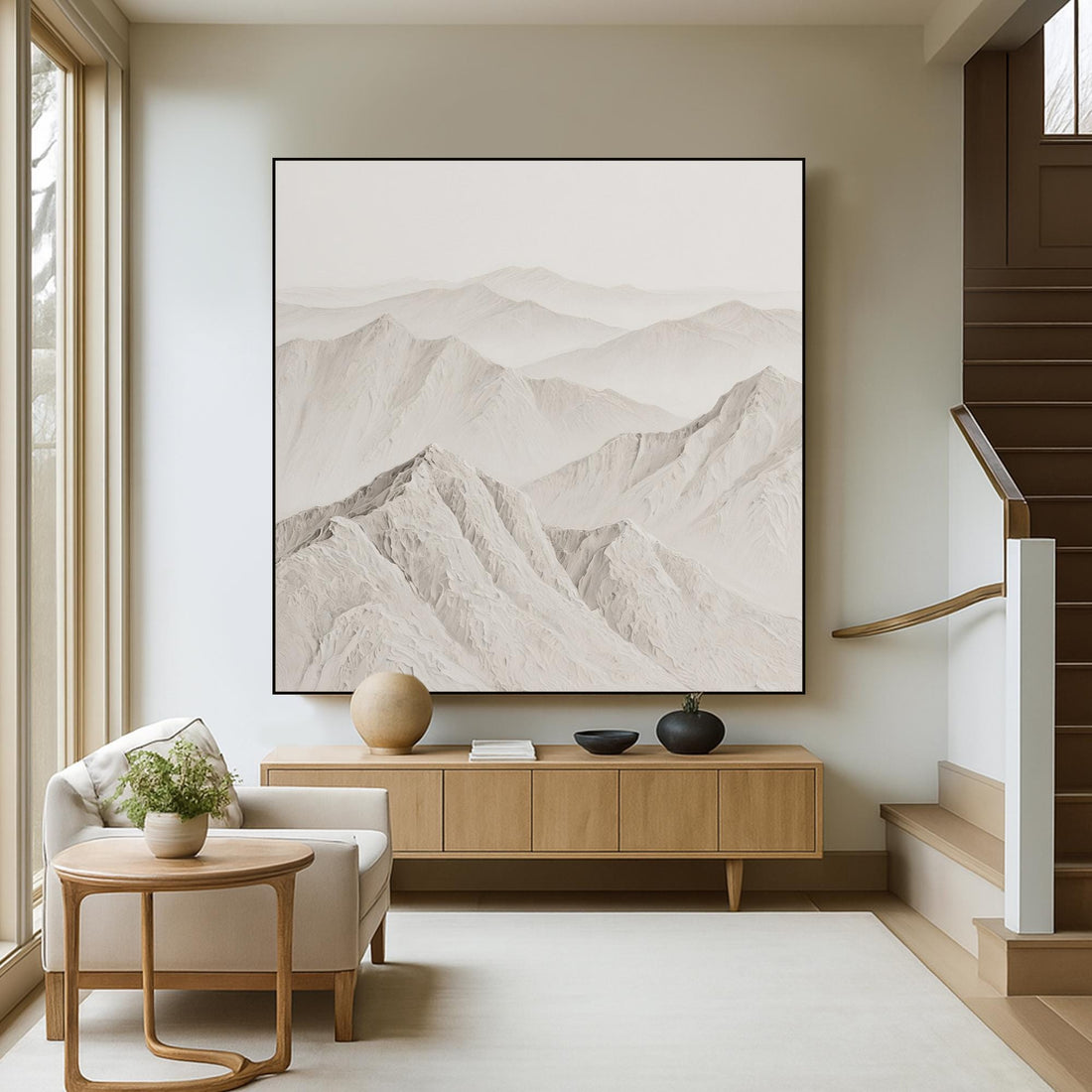 A serene landscape of snow-capped mountains, with their peaks gently rising against a hazy, pale blue sky.