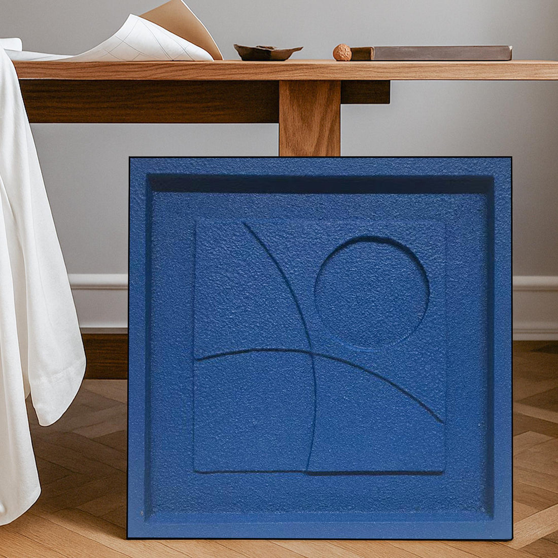 The image is a square-shaped artwork with a blue background and a central design featuring a circle and a line.