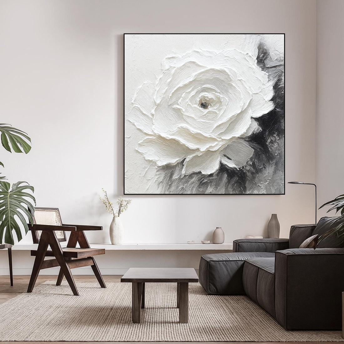 The image is a close-up of a white flower with a black center, set against a white background.